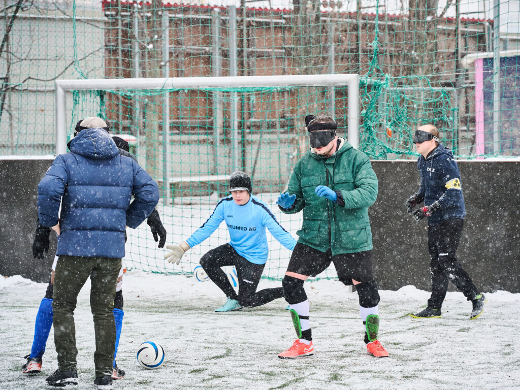 Spieler beim Blindenfußball mit blickdichten Masken in der Brigittenau.